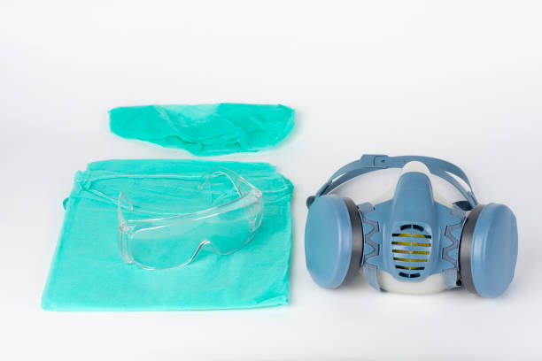 istock Twin filter half face respirator mask, plastic protective eyeglasses, protective gown, cap,  personal protective equipment to protect against the virus covid-19. 1218514425