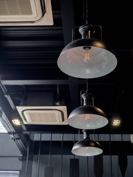 istock Three black round modern ceiling lights and cassette type air conditioner inside the cafe loft style. 1218516734