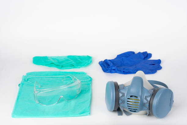 istock Twin filter half face respirator mask, plastic protective eyeglasses, protective gown, cap, pair of gloves,  personal protective equipment to protect against the virus covid-19. 1218517924