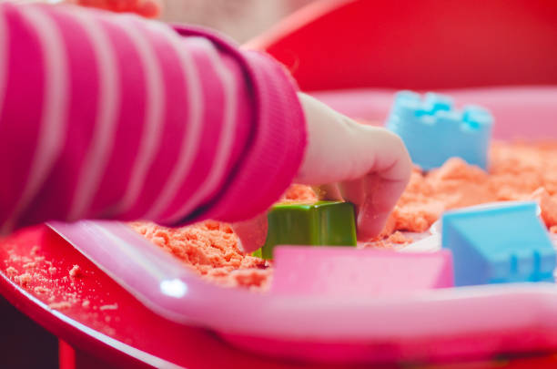 istock The hands of a child playing with kinetic sand 1218520048