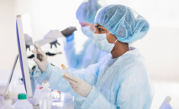 cientistas vestindo traje de proteção completo trabalhando em laboratório - 3097 - fotografias e filmes do acervo