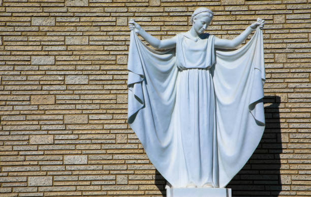 Female marble statue in front of a brick wall, Forest Lawn Memorial Park, Los Angeles