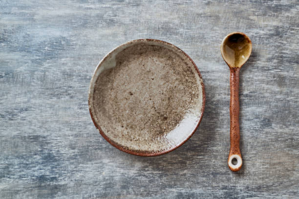 istock Empty ceramics plate and spoon on rustic wooden background. Top view. Copy space. 1218523275