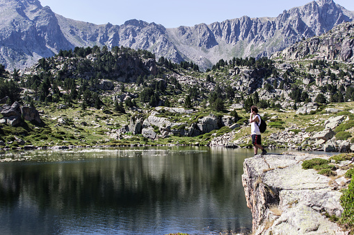 Man contemplating the reflection of the mountains in the lake. Pyrenees.