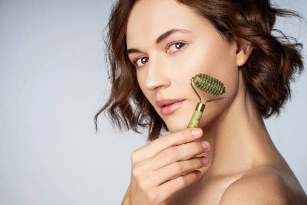 istock Jolly beautiful young lady with jade massaget 1218524344