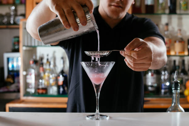 istock Bartender preparing red cocktail at cocktail glass at the bar. 1218524514
