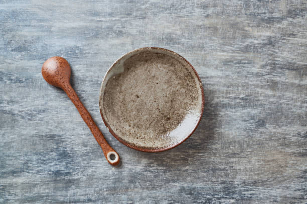 istock Empty ceramics plate and spoon on rustic wooden background. Top view. Copy space. 1218525662