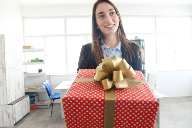 istock Young businesswoman holding a gift 1218525741