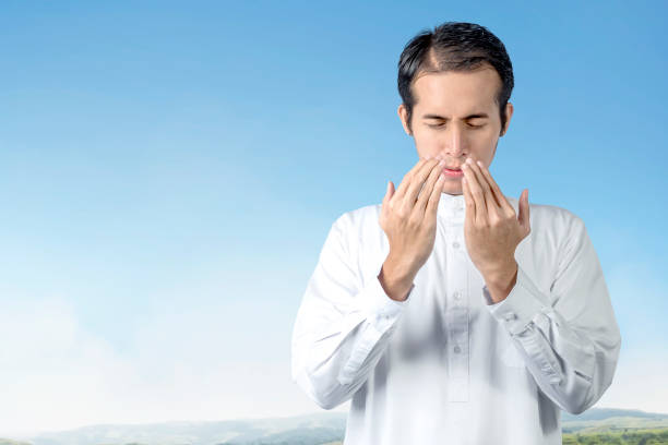 istock Asian Muslim man standing while raised hands and praying 1218525952