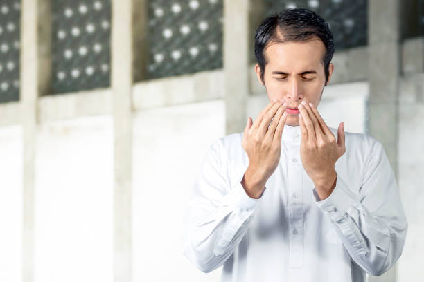 istock Asian Muslim man standing while raised hands and praying 1218525991