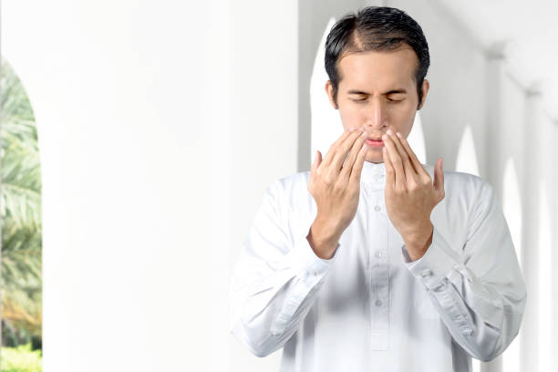 istock Asian Muslim man standing while raised hands and praying 1218526208