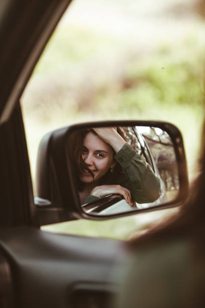 istock reflection on stunning smiling woman in car rear mirror 1218527168