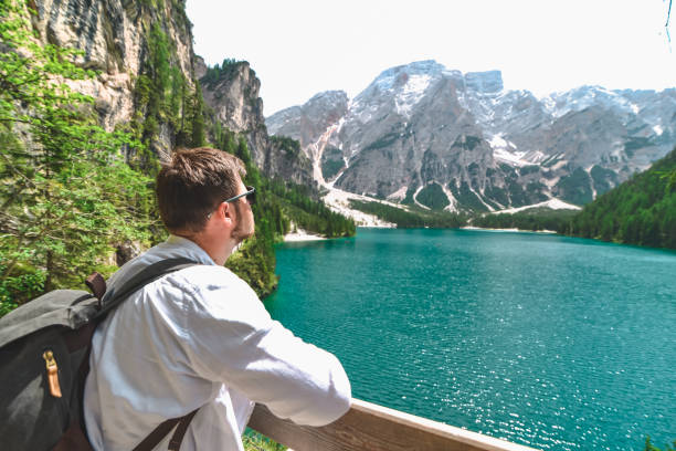 istock young strong man with backpack looking at lake in mountains 1218527249