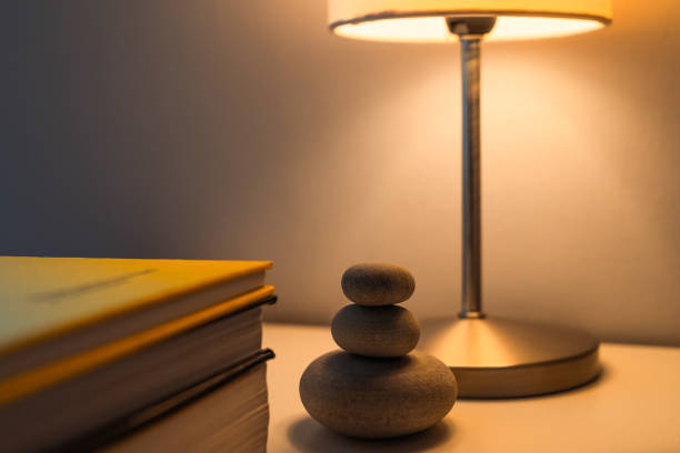istock Bedside table with books and a lighted lamp 1218527479