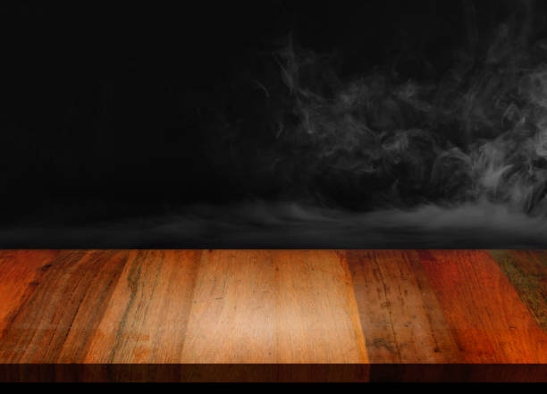 istock An old wooden table with smoke in a black background 1218527524