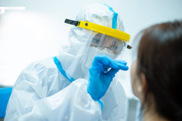 Coronavirus test concept Coronavirus test - Medical worker taking a swab for corona virus sample from potentially infected woman with the isolation gown or protective suits and surgical face masks medical swab stock pictures, royalty-free photos & images