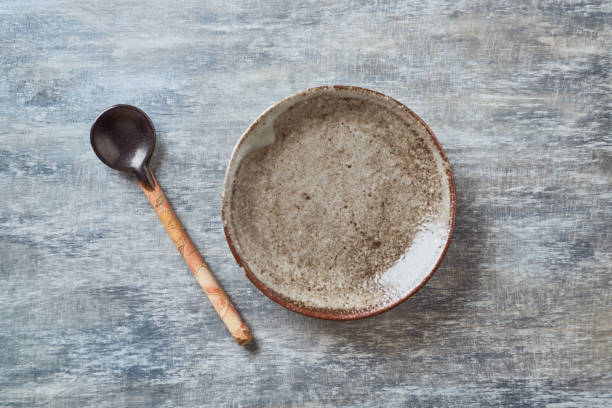 istock Empty ceramics plate and spoon on rustic wooden background. Top view. Copy space. 1218528819