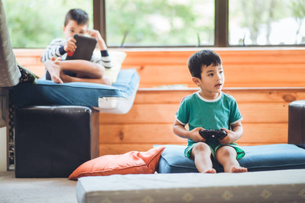 istock Kids at home busy playing on smart devices. 1218529145