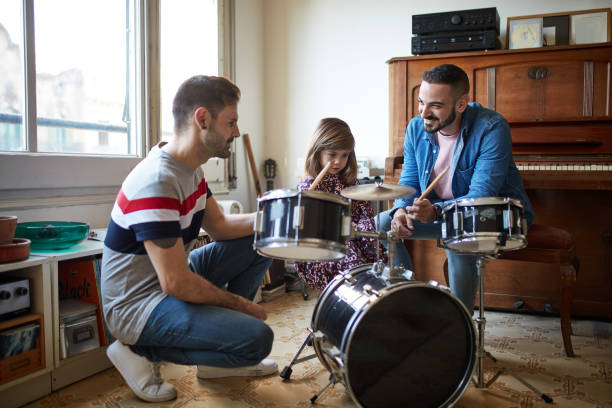 istock Fathers Watching as Young Daughter Learns to Play Drums 1218530928