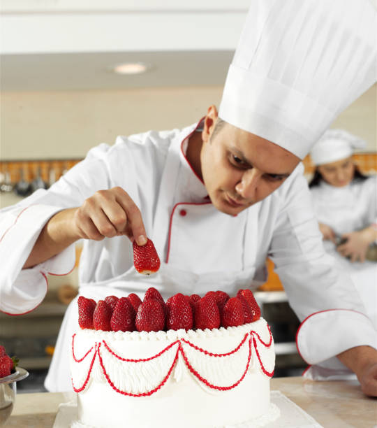 istock Male Chef Completing Strawberry Cake 1218533787
