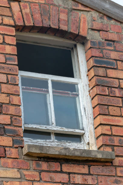istock a close up view of a small side window on a brick face buliding with one portion open 1218536091