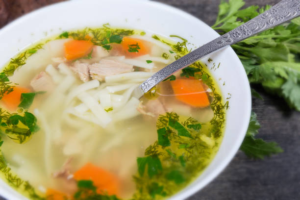 istock Chicken noodle soup in bowl with spoon, fragment close-up 1218537297