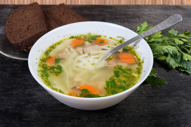 パンと緑に対するボウルのチキンヌードルスープ - soup chicken soup chicken noodle soup food ストックフォトと画像