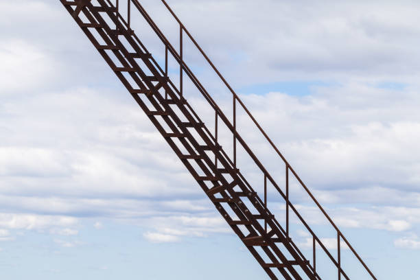 istock Rusty metal stairway goes up under cloudy sky 1218537511