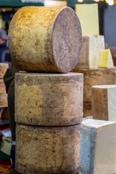 istock Stack of Cheddar cheese wheels on a market stall 1218537715