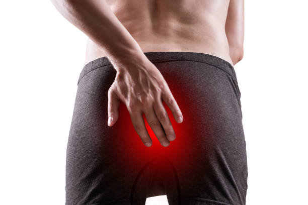 Man suffering from hemorrhoids, anal pain, isolated on white background Man suffering from hemorrhoids, anal pain, isolated on white background, painful area highlighted in red coccyx photos stock pictures, royalty-free photos & images