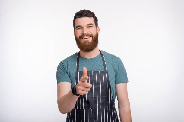 istock young handsome Chef man pointing confident at the camera standing over white background 1218538973