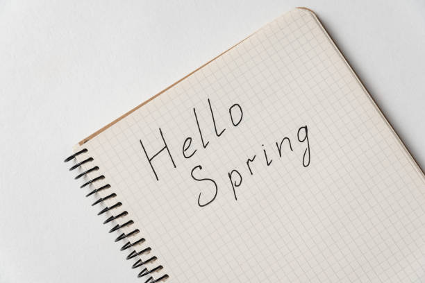 istock Notepad with the words Hello spring. Copybook on white background, close up 1218539840