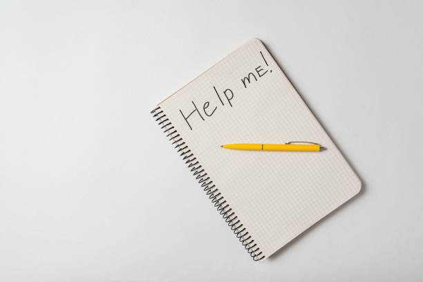 istock Top view of the notepad with Help Me notice on a white background. Request for assistance sos 1218539845