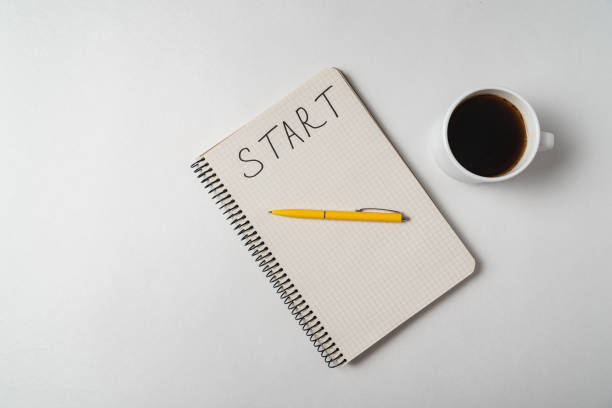 istock Word START written on notebook over white background. Top view of copybook and coffee 1218539863