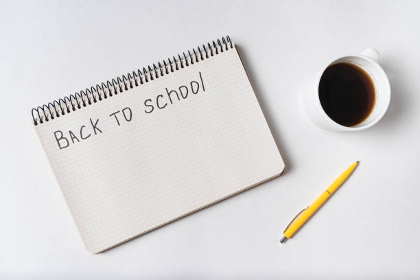 istock Handwriting notice in notebook BACK TO SCHOOL. Pen, notepad and cup of coffee, top view 1218539952