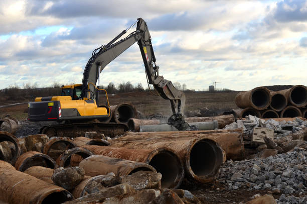 istock Excavator with hydraulic shears on a construction site cuts and crumbles old concrete and asphalt. Hydraulic breaker grinder. Crusher concrete slabs, breaker crushes, hydraulic shears. 1218540796