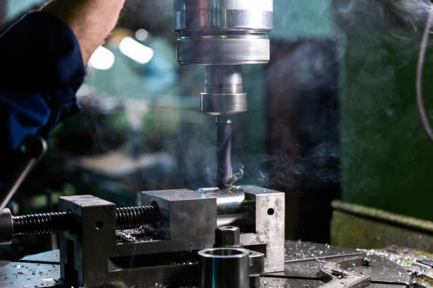 istock Industrial steel drilling process with smoke. Close-up with selective focus. Manual feed by hand. Workpiece in vise on table. 1218541149