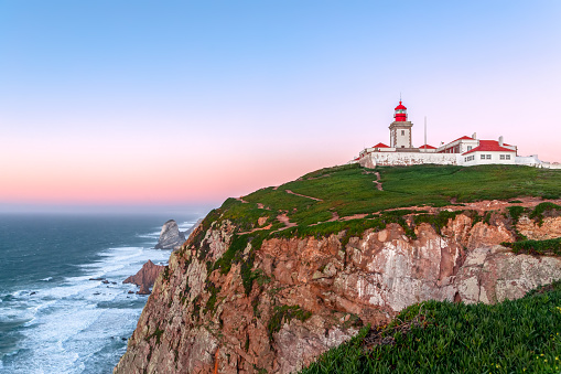 Cabo da Roca, Sintra, Portugal. Lighthouse and cliffs over Atlantic Ocean, the most westerly point of the European mainland at sunset.