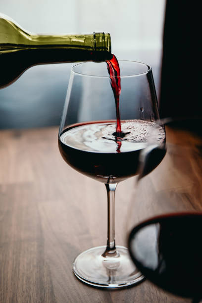 istock Red wine glass on a wooden table at home 1218542826