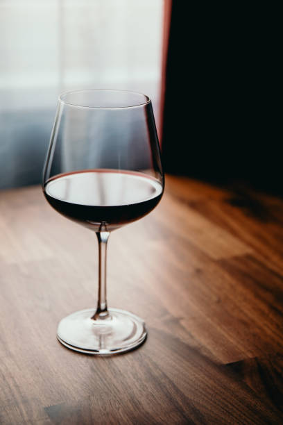 istock Red wine glass on a wooden table at home 1218542827