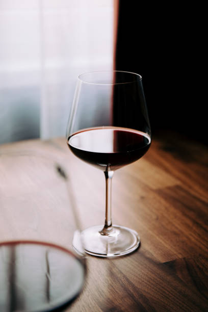 istock Red wine glass on a wooden table at home 1218542832