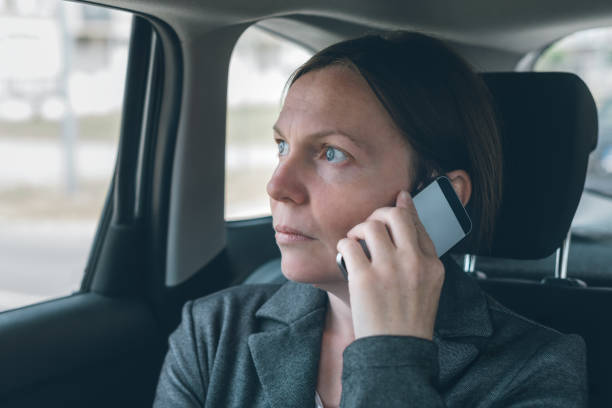 istock Businesswoman talking on mobile phone on car back seat 1218545656