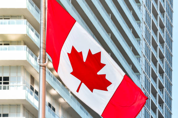Canadian flag in daylight on a metal and glass office building background. Toronto, Ontario, Canada stock photo
