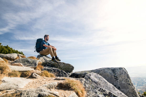 istock Mature man with backpack hiking in mountains in autumn, resting. 1218549830