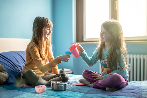 Sisters playing on bed during lockdown quarantine