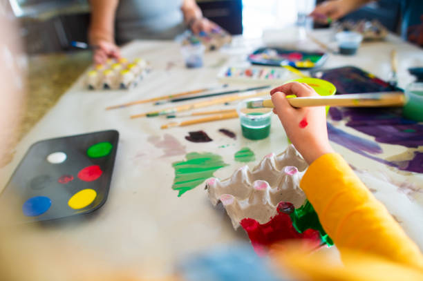 istock Home school art and craft class painting egg holders with bright colours personal perspective 1218551382
