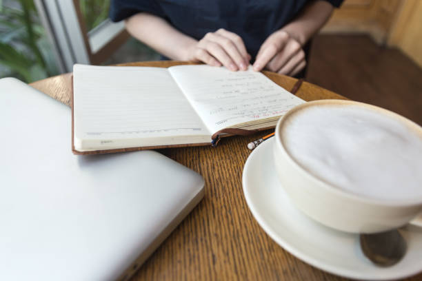 커피 컵, 노트북 및 노트북을 가진 여자의 손은 테이블에 비즈니스를 위한 메모를, 닫는 - connection usa coffee cup mug 뉴스 사진 이미지