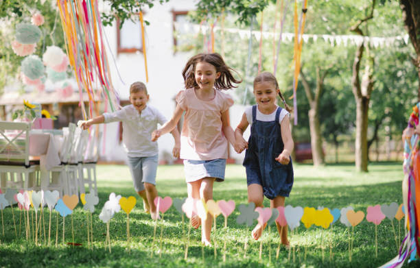 istock Small children outdoors in garden in summer, running when playing. 1218554792