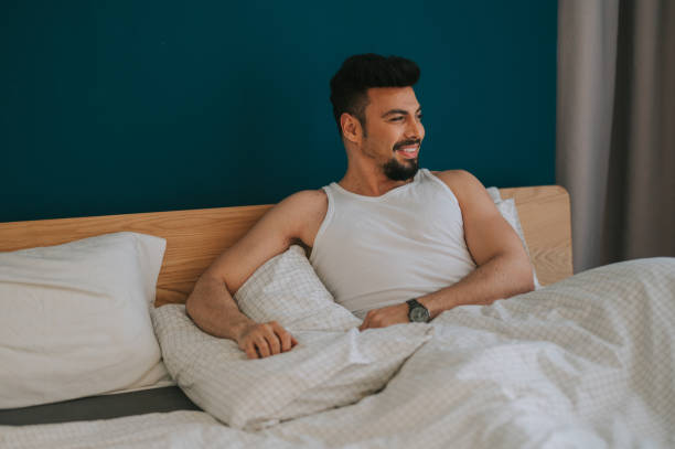 istock a middle eastern man on bed leaning and resting with blanket comforter in bedroom 1218554894
