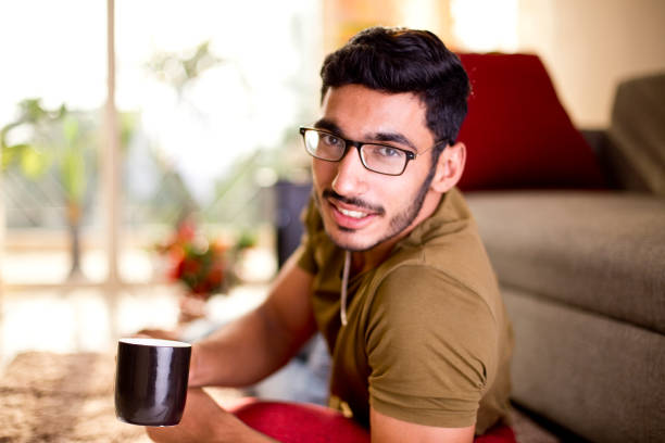 istock Young man drinking coffee at home 1218556199